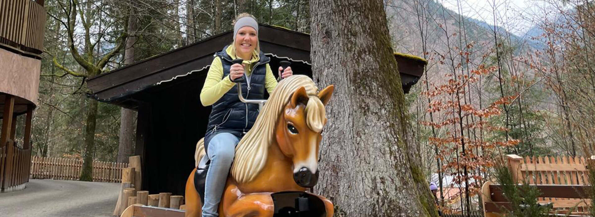 Frau testet HopplaHopp Pferdereitbahn im Freizeitpark