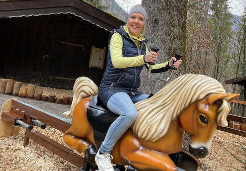 Frau testet Hoppla Hopp Pferdereitbahn